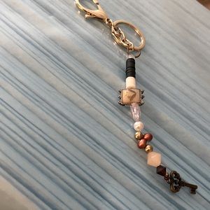Gold and brown keychain with gold key ring with stretchy string and key